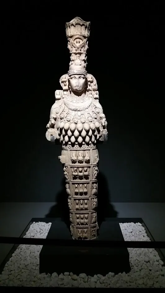 The Artemis of Ephesus, a marble cult statue lit in a darkened gallery