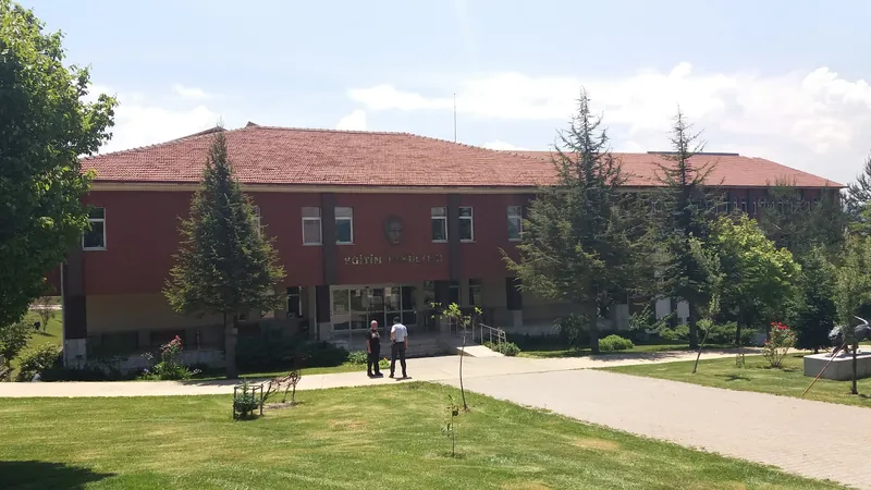 A faculty of education building with a red brick facade and lawn in front